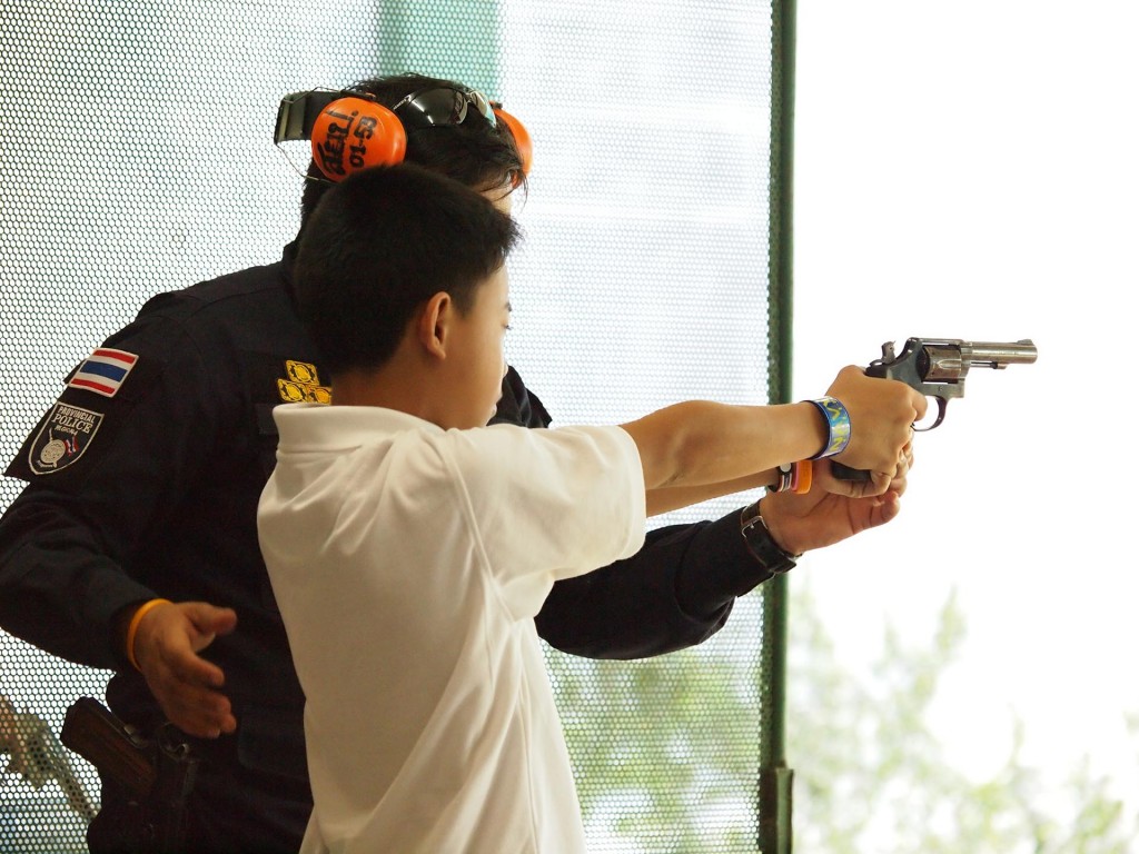 Instructor Teaching a Boy How to Use a Handgun